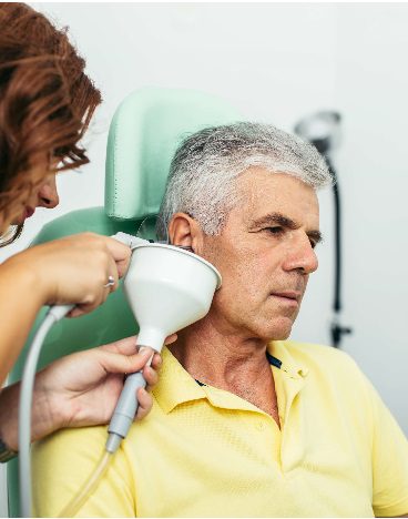 Audiologist performing earwax removal using an earigator